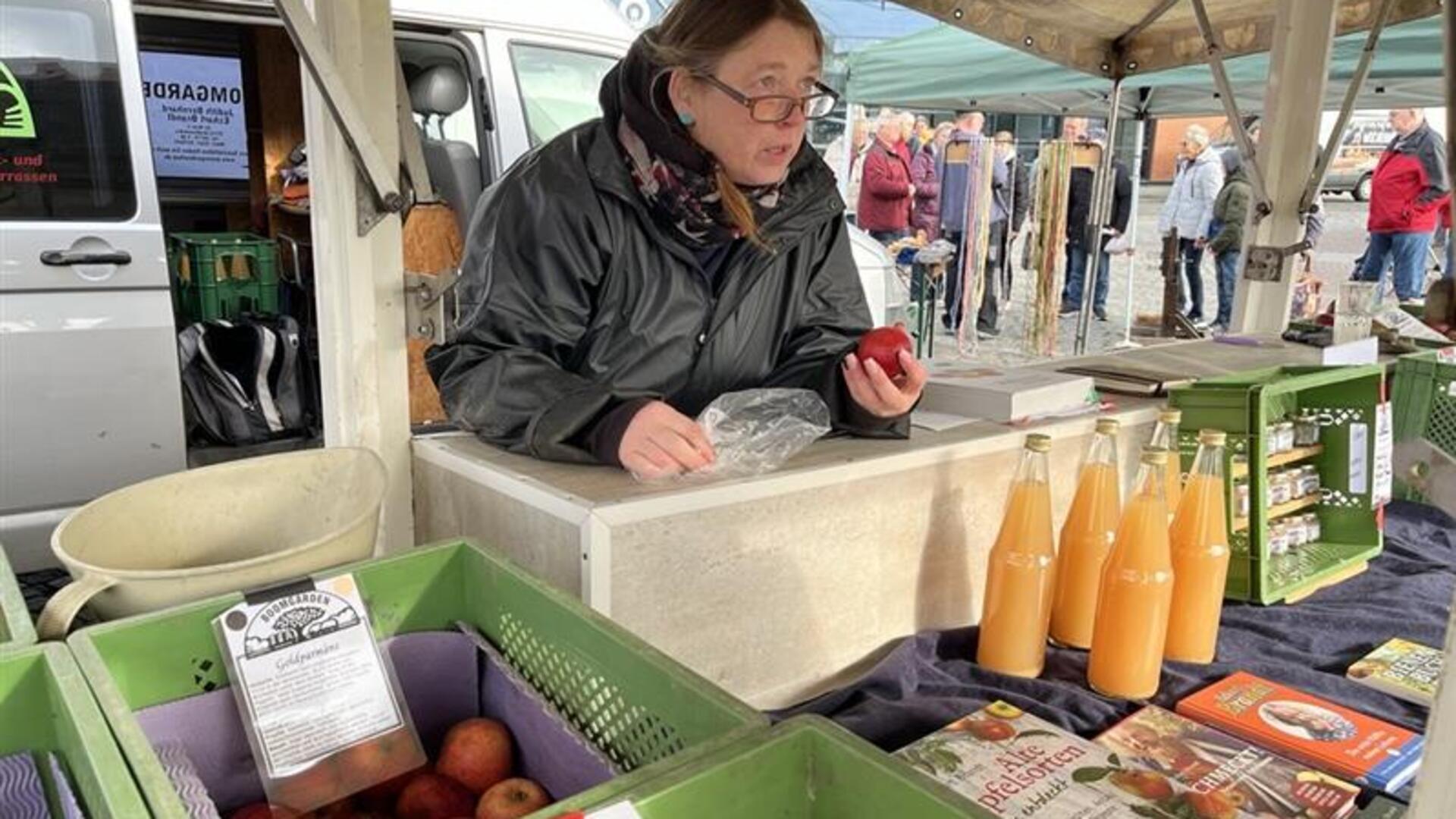Judith Bernhard, die zusammen mit Eckart Brandt in Helmste alte Obstsorten kultiviert, bestimmt beim Bauernmarkt in Bremerhaven mitgebrachte Äpfel.