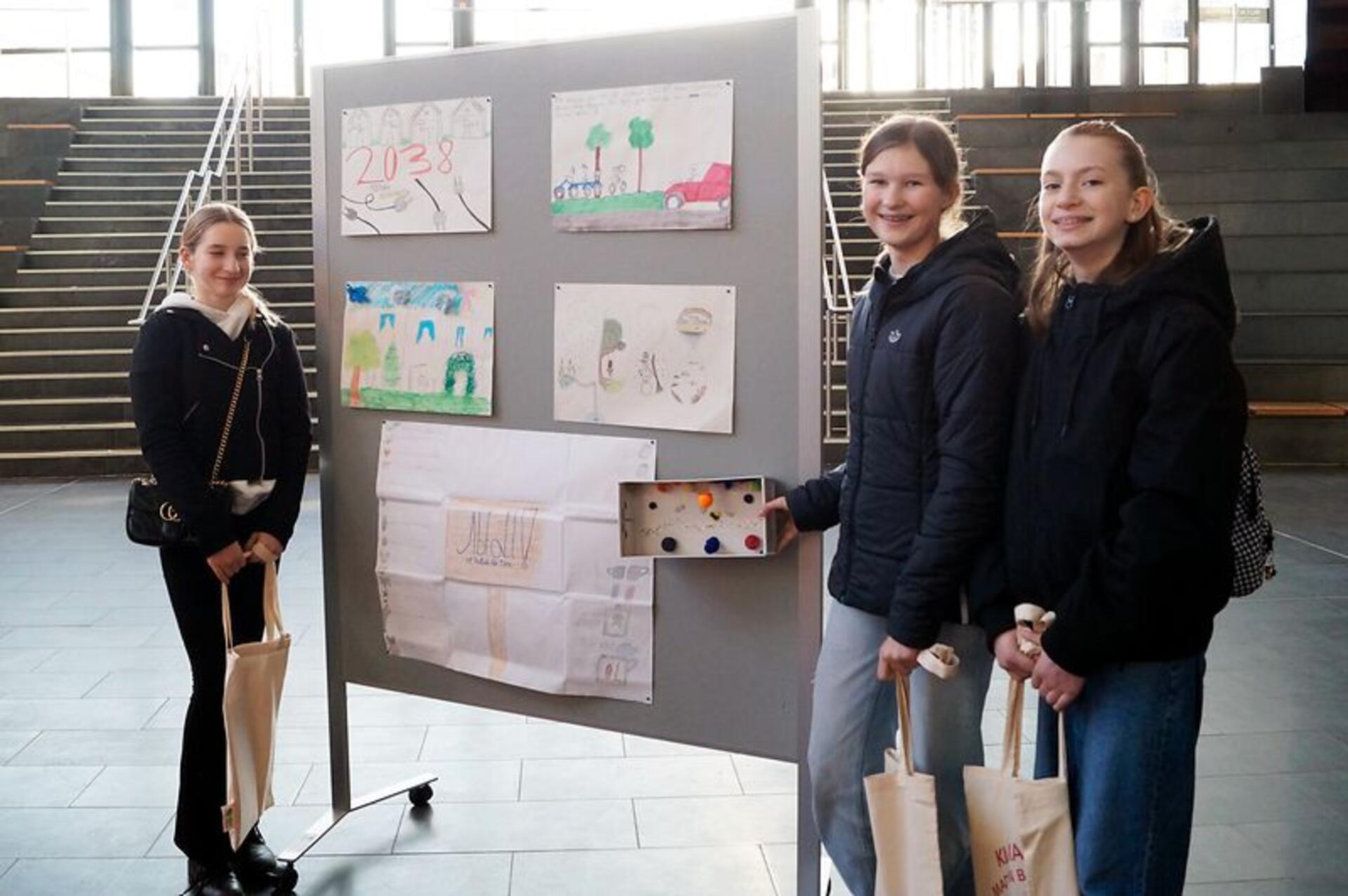 Drei Schülerinnen stehen an einerm Flipchart - eine links an dem Tafelschreibblock, die anderen beiden Mädchen rechts. Sie haben sich mit Mitschülerinnen Gedanken für ein grüneres Bremerhaven gemacht. 
