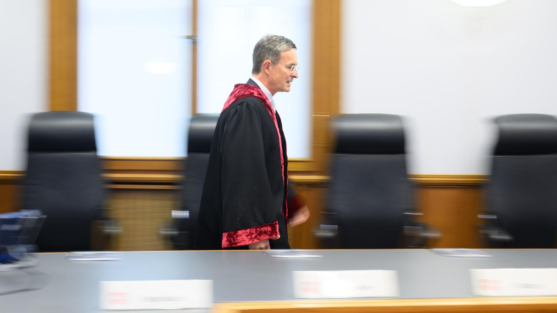 ein Richter in Robe betritt einen Gerichtssaal