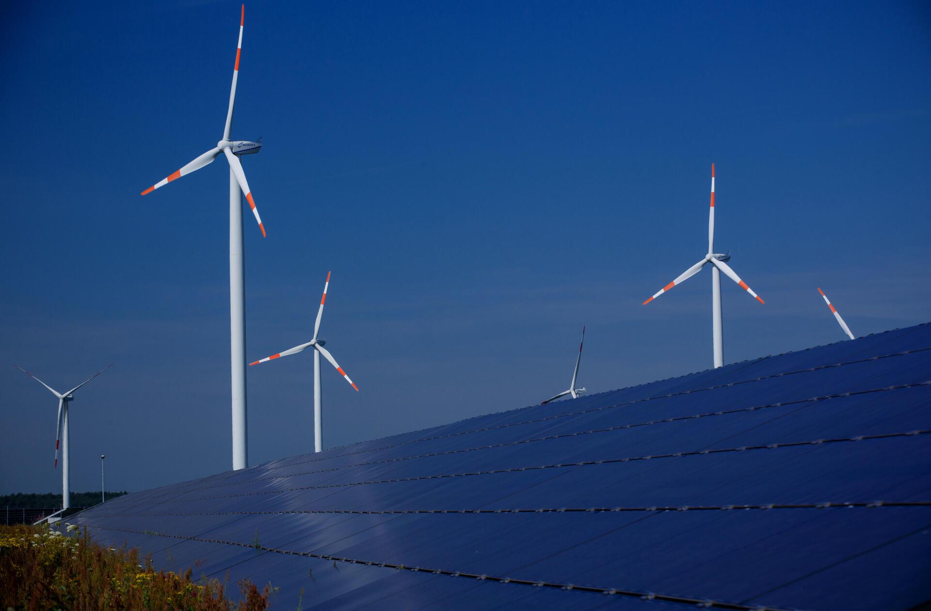 Windräder zur Stromerzeugung drehen sich hinter einem Solarpark: In Wilstedt regt sich heftiger Widerstand gegen den Bau einer FFPV-Anlage.