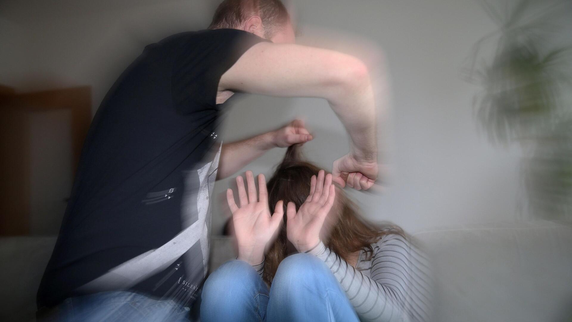 Symbolbild: Ein Mann schlägt mit der Faust auf eine Frau ein und zieht ihr an den Haaren. Sie hält ihre Hände schützend vor ihr Gesicht  