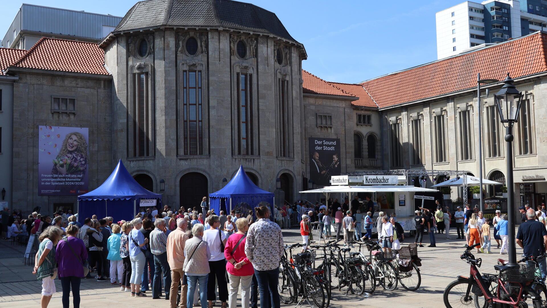 Menschen stehen vor dem Gebäude des Bremerhavener Stadttheaters. 