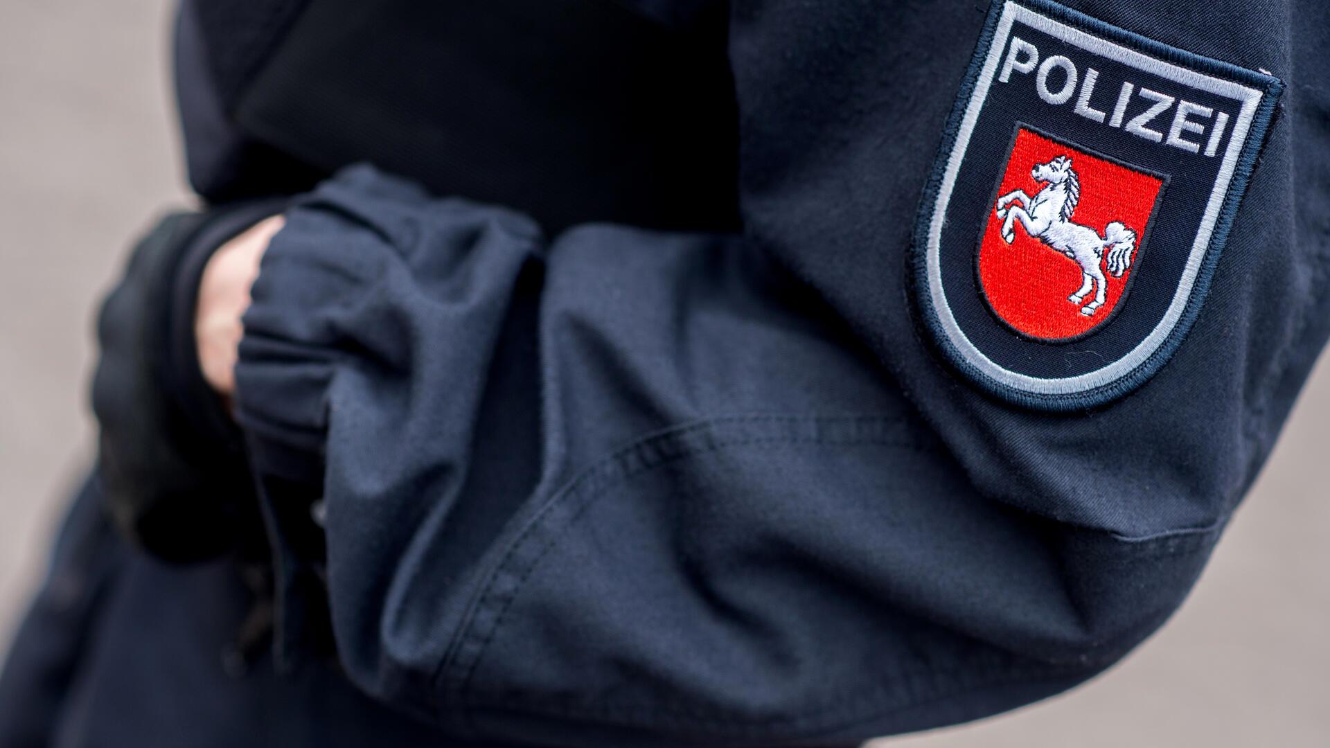 Eine Polizeibeamtin steht im Innenhof einer Polizeiinspektion 