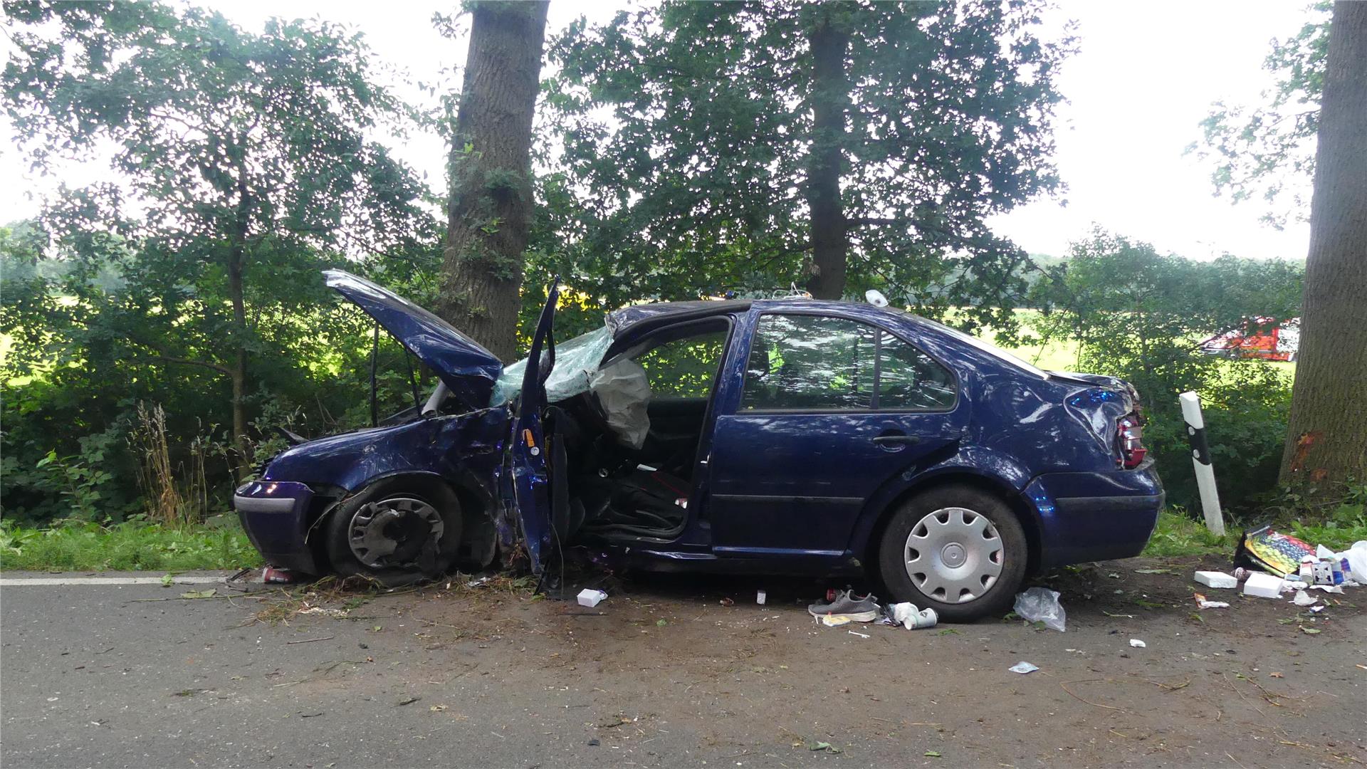 Ein verunfalltes Auto, das gegen einen Baum geprallt ist. 