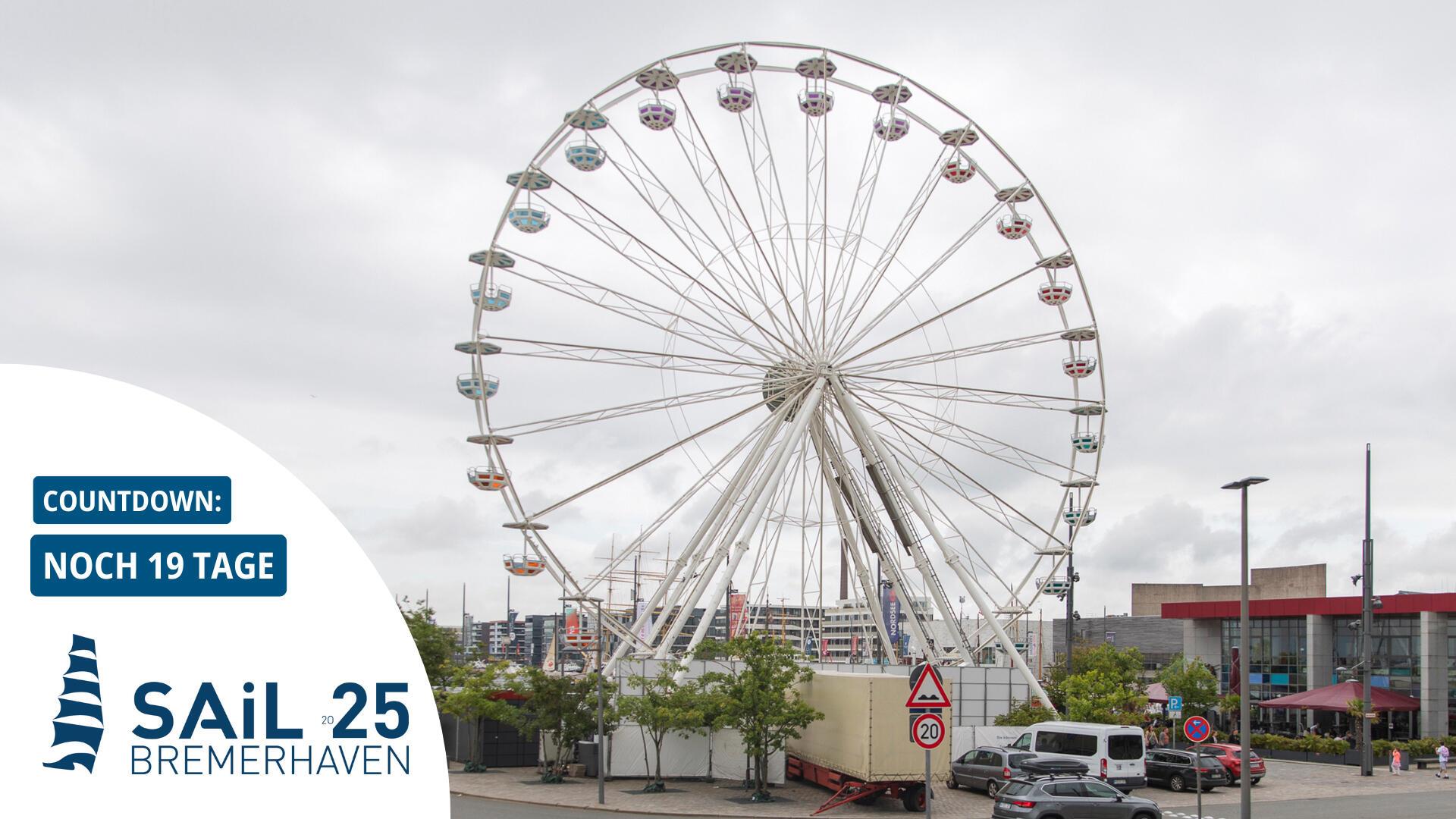 Ein Riesenrad steht in einer Stadt. Der Himmel ist bedeckt.